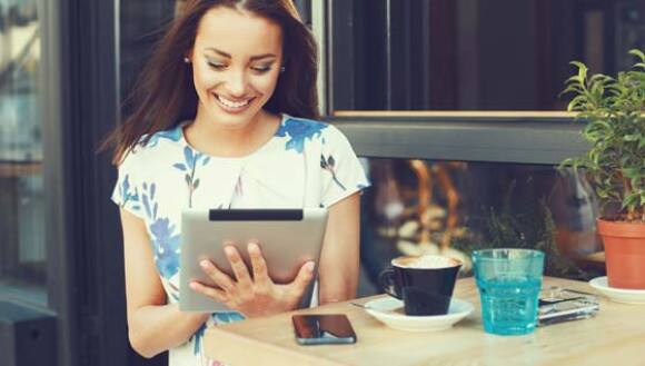 Person using a tablet at a cafe