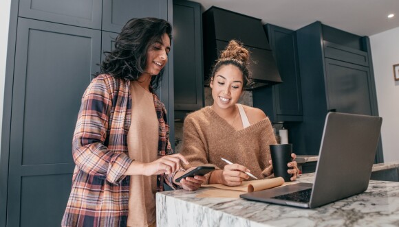 Woman showing her mobile phone to another woman