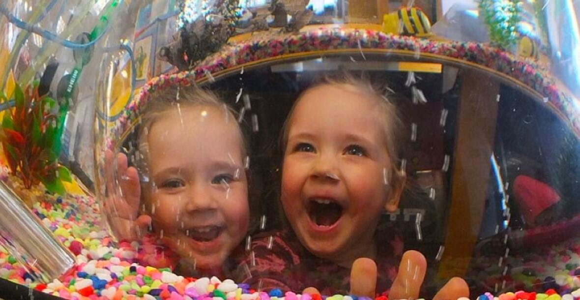 Two kids looking happy in front of a candy store