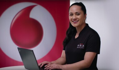 A female Vodafone Ninja types on her laptop