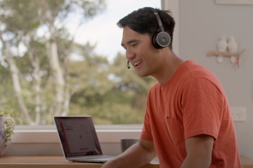 Man working on his laptop wearing headset