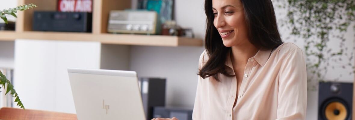 Woman working on laptop with coffee cup on table