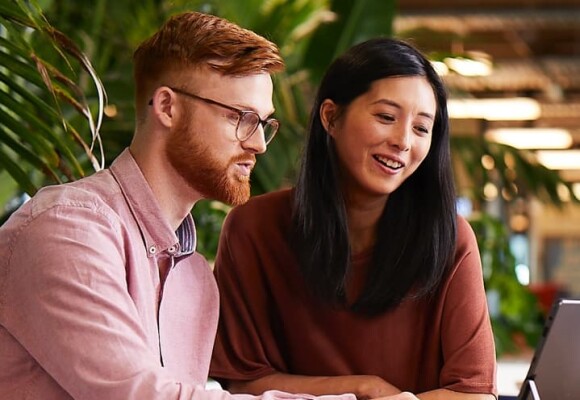 Man and woman looking at a laptop in an office