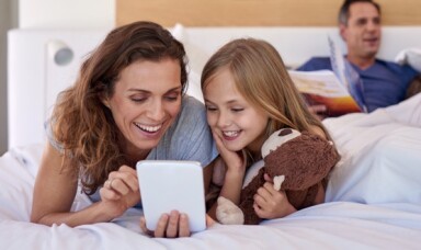 Family smiling looking at a tablet