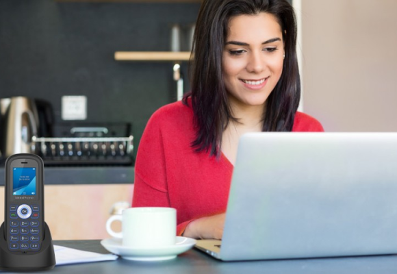 woman in red smiling and typing on her laptop