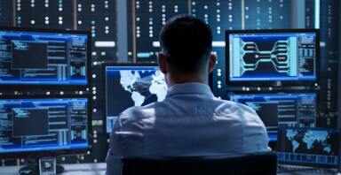 Man looking at multiple computer screens