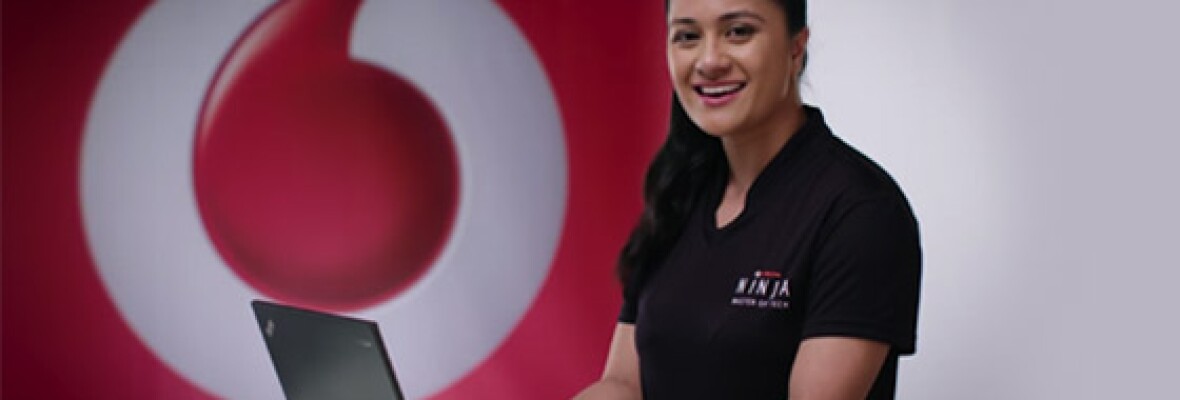 A female Vodafone Ninja types on her laptop