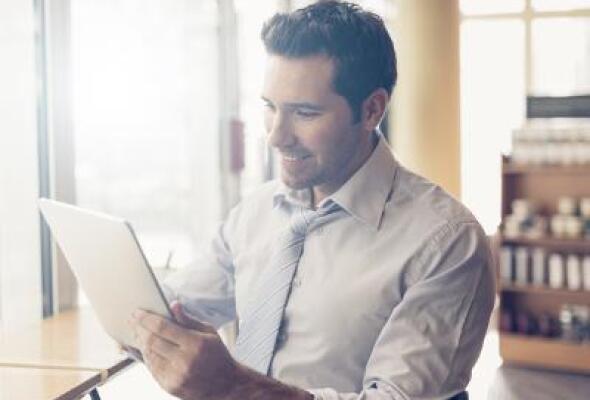 Man looking at a tablet ata cafe