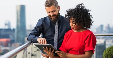 A man and a woman looking at a tablet