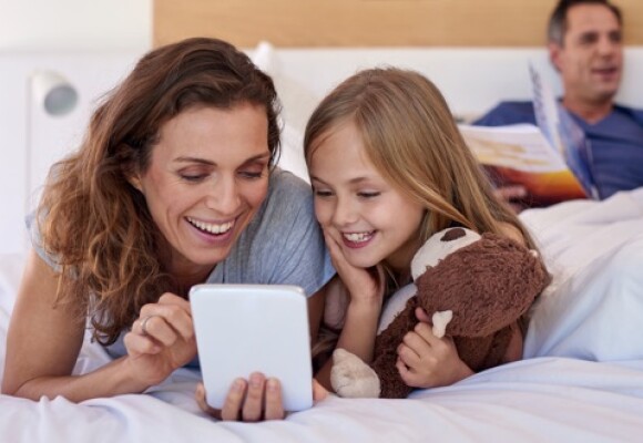 Family smiling looking at a tablet