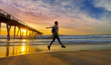 Person on a beach with sunset in the background
