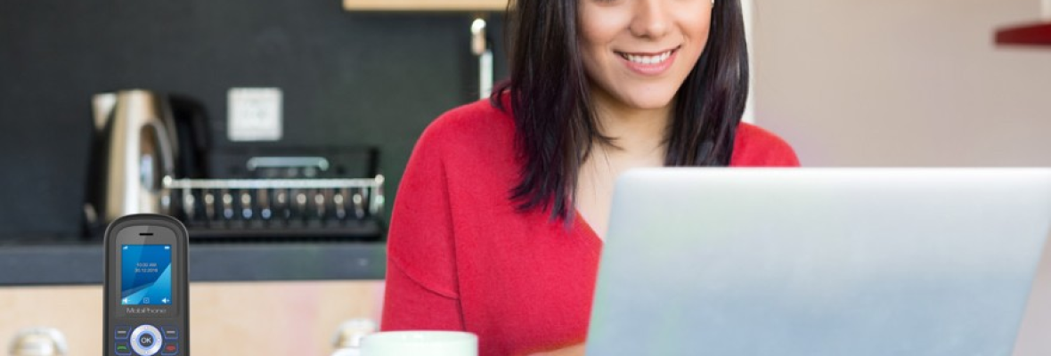 woman in red smiling and typing on her laptop