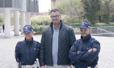 Man standing between two New Zealand police officers