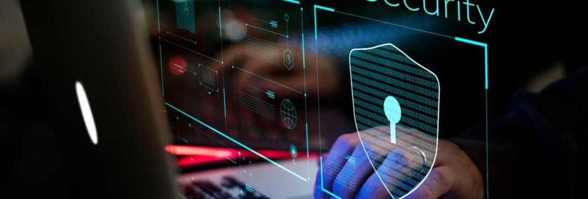Person working on a laptop showing cyber security logo