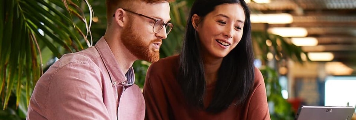 Man and woman looking at a laptop in an office