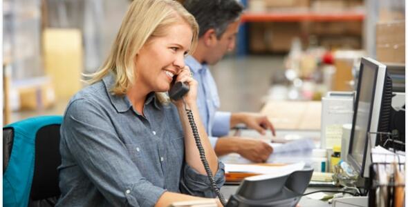 Lady smiling on a phone call to customer in a sales office