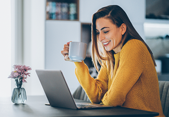 lady working on a laptop drinking coffee