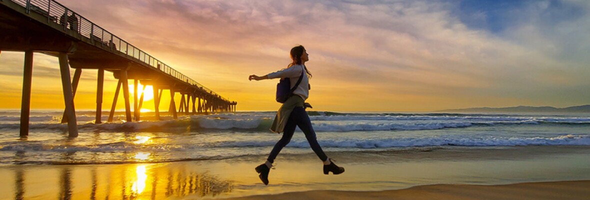 Person on a beach with sunset in the background