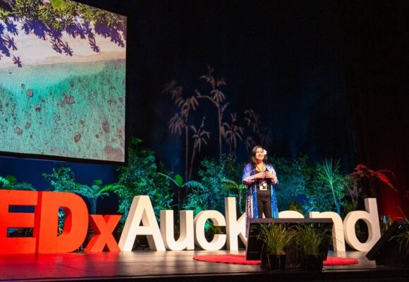 A woman onstage speaking at TEDxAuckland tūmanako