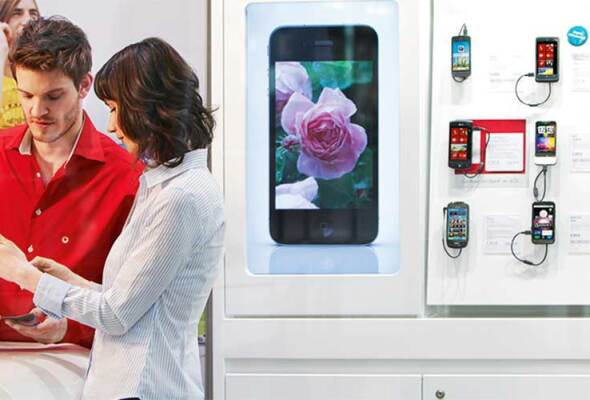 A man and a woman in a Vodafone retail store looking at a mobile phone