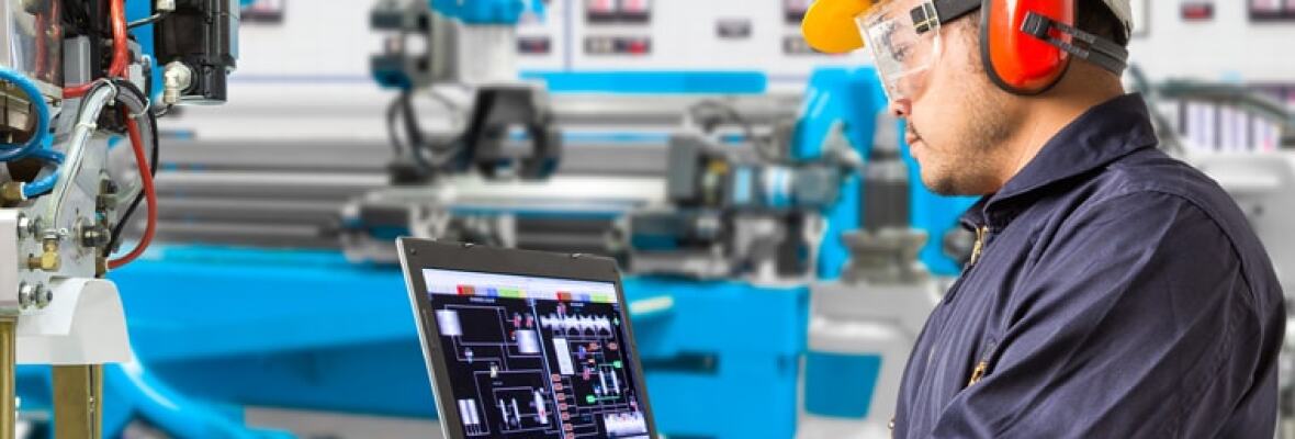 Man working on a laptop at a factory