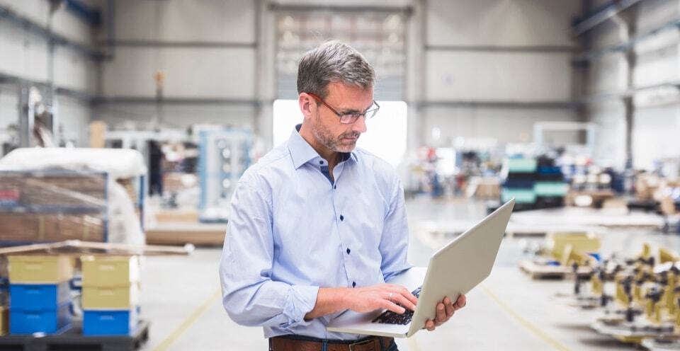Man looking at a laptop in a warehouse