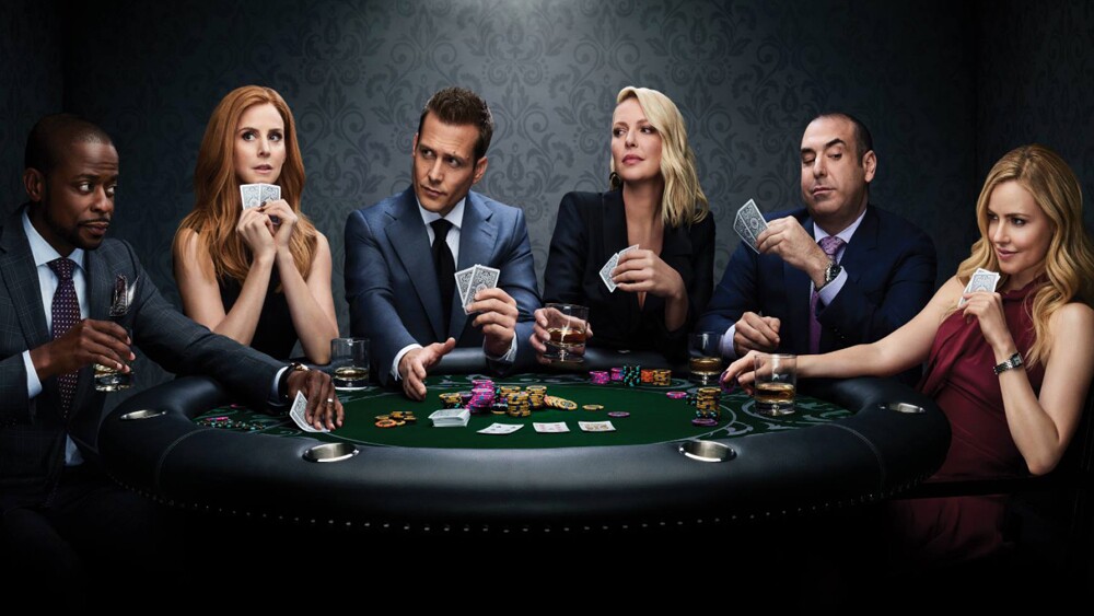 cast of suits sat around a table playing cards