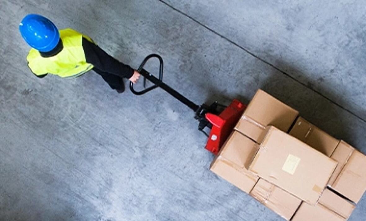 A worker pulling a trolley at a factory