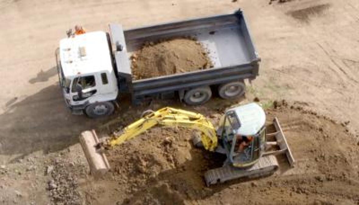 A truck and a bulldozer working on a land