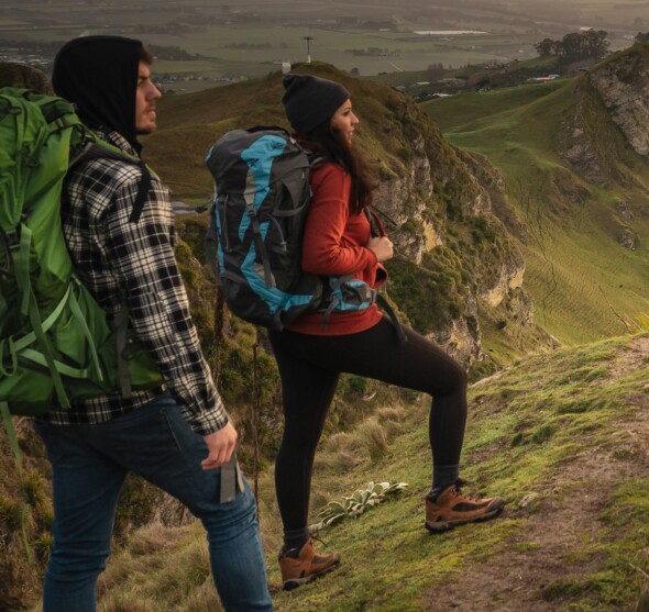 A couple hiking on steep countryside.