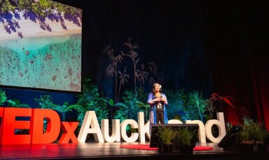 A woman onstage speaking at TEDxAuckland tūmanako