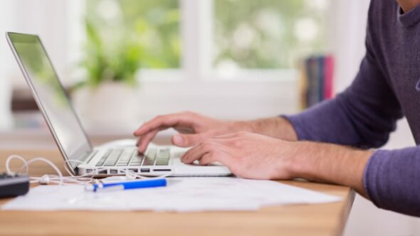 man typing on a laptop