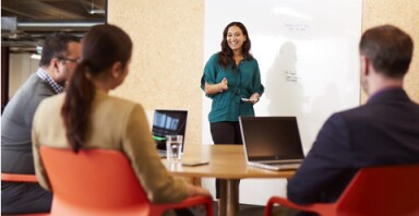 Woman in an office showing presentation to collegaues