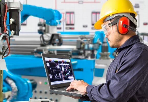 Man working on a laptop at a factory