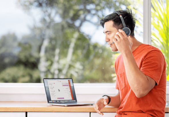 Man in orange shirt working at home