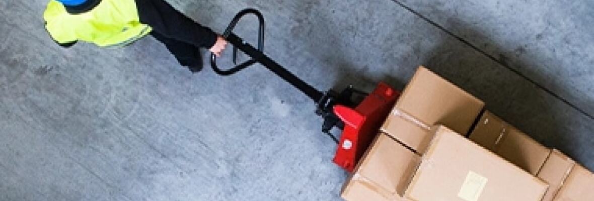 A worker pulling a trolley at a factory