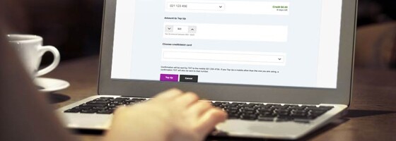 Person using a laptop with the Vodafone website's Top up screen.