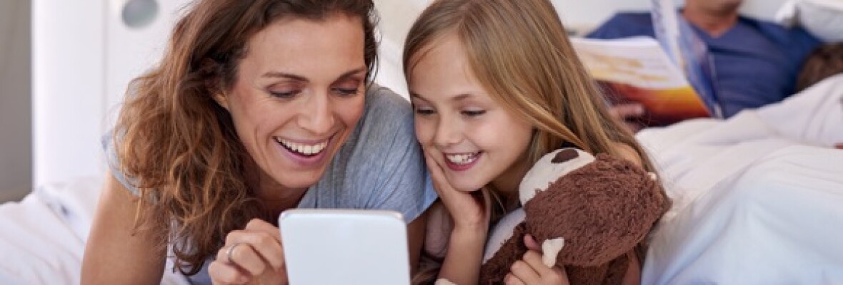 Family smiling looking at a tablet