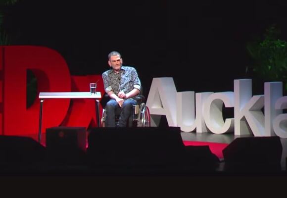 Philip Patston onstage speaking at TedX Auckland.