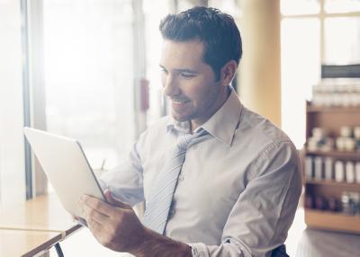 Man looking at a tablet ata cafe