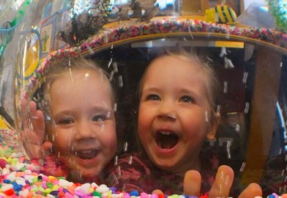 Two kids looking happy in front of a candy store