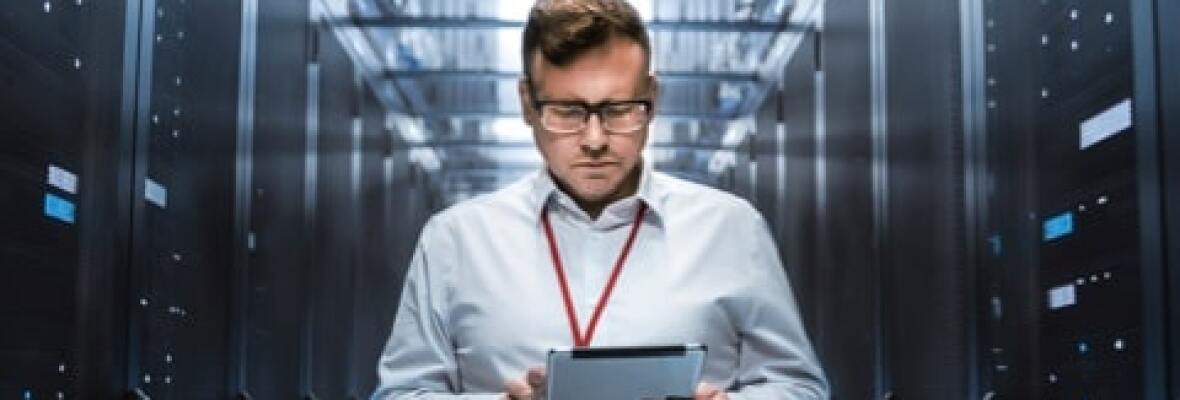 Man looking at a tablet in a server room