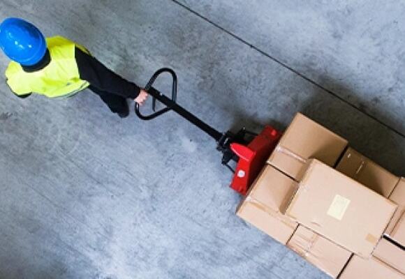 A worker pulling a trolley at a factory
