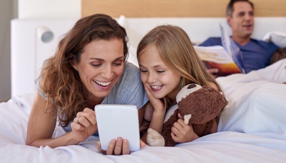 Family smiling looking at a tablet