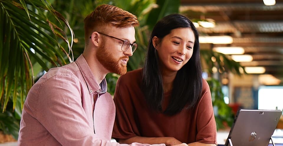 Man and woman looking at a laptop in an office
