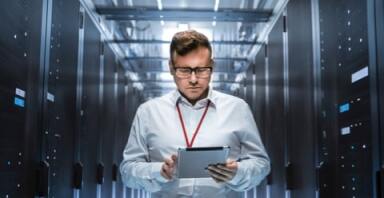 Man looking at a tablet in a server room