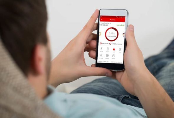 Man laying with a phone looking at My vodafone app