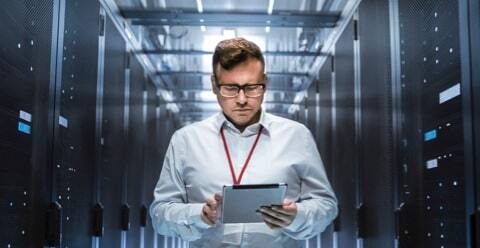 Man looking at a tablet in a server room