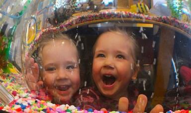 Two kids looking happy in front of a candy store