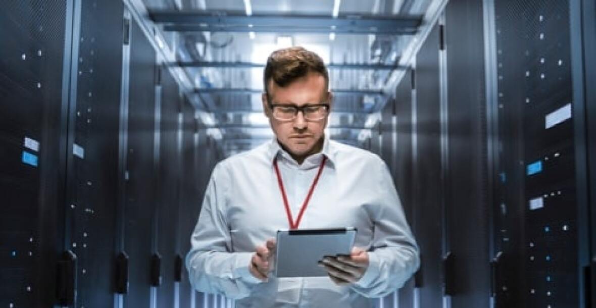 Man looking at a tablet in a server room